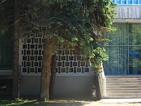 белое фигурное ограждение на широком бетонном крыльце с перилами гостиницы "Дубна" времен СССР в лесной зоне