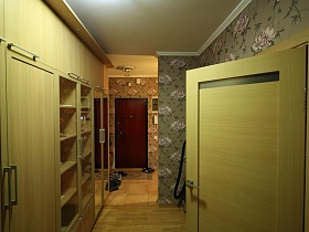 оливковые обои с большими сиреневыми цветами на стенах и шкафы оливкого цвета в прихожей современной трехкомнатной актерской квартиры