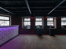 железные бочки на деревянном полу,квадратные подушки на широких подоконниках больших окон в кирпичных стенах ночного клуба с длинной барной стойкой