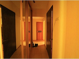 шкаф-купе с зеркальными дверьми в желтом коридоре приличной двухкомнатной квартиры жилого дома