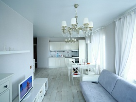 общий вид светлой просторной зонированной комнаты с белой мебелью стильной квартиры блогера