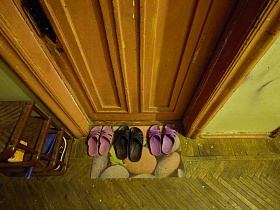 аккуратно стоящие шлепки на коврике у входной двери в жилую комнату общежития