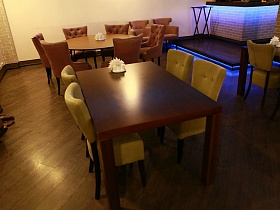 столы с креслами и стульями на полу с линолеумом под дерево в уютном зале хорошего ресторана на Юге Москвы