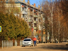 знак пешеходного перехода на широкой дороге вдоль пятиэтажного монолитного жилого дома в Сычево для съемок кино
