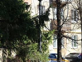 белый закрытый плафон уличного черного фонаря на фоне жилого дома провинциального городка