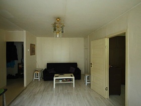 темно серый мягкий диван с подушками у стены белой гостиной съемной квартиры