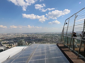 вид с открытой смотровой площадки на город и прозрачную крышу нижнего этажа небоскреба Москва Сити