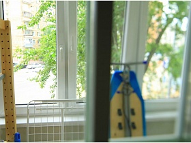 гладильная доска, сушилка для белья на застекленном балконе однокомнатной евартиы в жилом доме