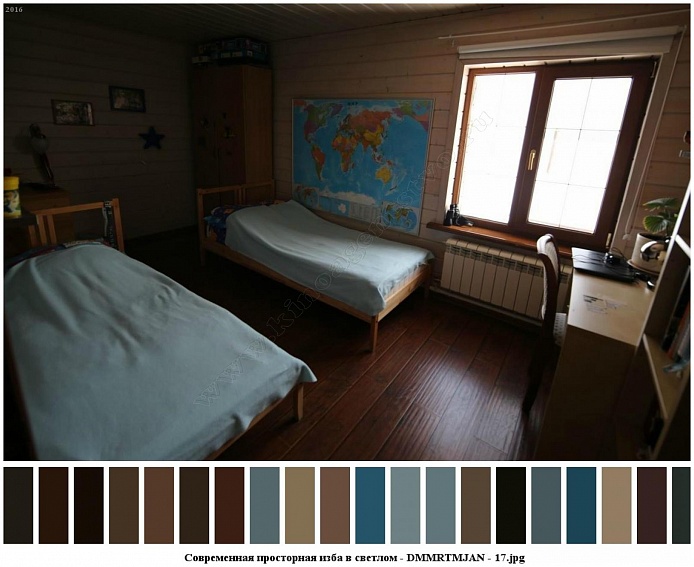 две деревянные кровати, большая карта мира на стене и письменный стол у окна спальни в современном деревянном просторном доме