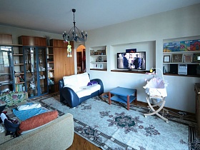 фотографии, картины, иконы и телевизор в нише стенки под мебель, сине белый диван , мебельная стенка в гостиной простой семейной трешки
