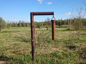 сигнальный металлический колокол на краю старой российской деревни в лесной зоне