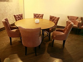 шесть персиковых мягких кресел вокруг круглого стола в уютной зоне хорошего ресторана на территории автобазы Юга Москвы