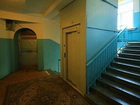ковер на полу лестничной площадки  у дверей лифта в жилом доме