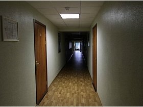 двери в номера на противоположных сторонах длинного коридора