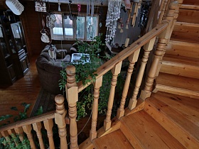 многочисленные обереги и звоночки над деревянной лестницей в гостиной загородной дачи