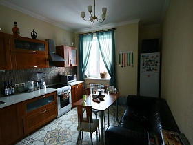 бутылки с напитками и электроприборы на белой столешнице коричневой кухни в квартире в переезде (въезде) молодоженов