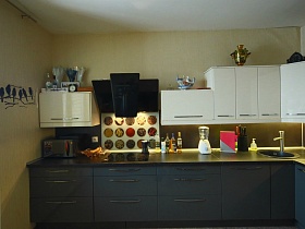 микроволновка, кофеварка, подставка с ножами на черной столешнице двухцветной мебельной кухни в современной квартире в Химках