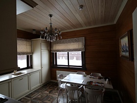 кухня с белой мебелью в деревянном современном съемном коттедже