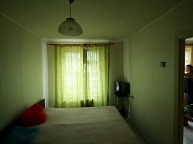 узкая спальня в съемной квартире с большой кроватью