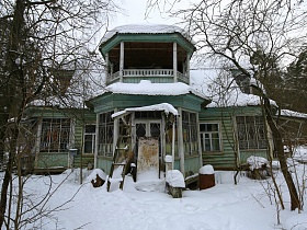 деревянная лестница и доска на крыльце у входных дверей на дачу художника советских времен на зимнем участке