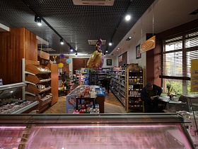 большие цветные бумажные шары, объемная сказочная принцесса на веревочке украшают помещение магазина с кондиционерами и трековыми светильниками на решетчатом потолке