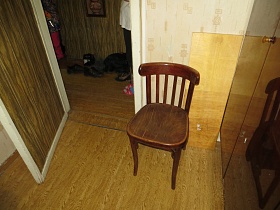 полированный стул с полукруглой спинкой рядом со  шкафом для одежды у открытой двери в прихожую квартиры СССР