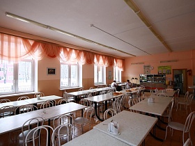 белые чистые столы в три ряда большой столовой типовой школы