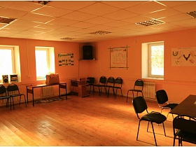 стулья и столы под окнами и у стен с плакатами в просторной учебно-познавательной комнате школы в селе
