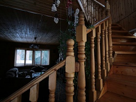 деревянная лестница с резными перилами на второй этаж современной загородной дачи