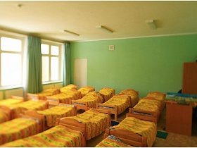 аккуратно застеленные кровати в светлой детской для сна