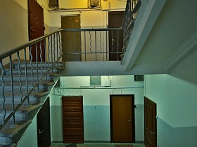 четыре жилые квартиры на каждом этаже серого подъезда 12 с винтовой лестницей многоэтажного дома времен СССР