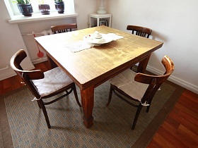 квадратный раздвижной деревянный стол с 4 стульями на ковре в кухне сталинки
