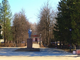 памятник В.И.Ленину на центральной площади, выложенной плиткой, в окружении старых,высоких елей в Сычево для съемок кино