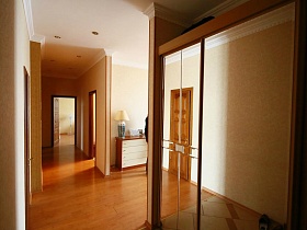 шкаф-купе с зеркальными дверцами в светлой прихожей трехкомнатной квартиры на седьмом этаже жилого дома