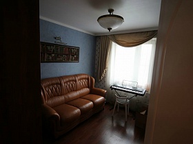 вид на гостиную с голубыми стенами и белым потолком с закрытой люстрой через открытую дверь в семейной трешке