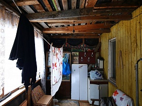 ненужная мебель в хоз постройке с незашитым потолком