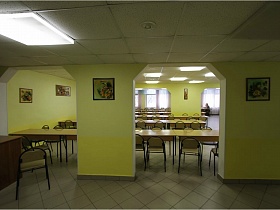 красочные картины на желтых широких колоннах в раздельных залах столовой типового здания школы 2000г г