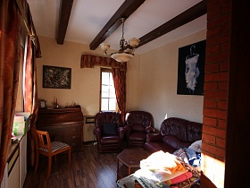 восьмигранный журнальный столик у кожанного мягкого дивана и кресел, стул у пианино в кабинете с коричневыми шторами на окнах и картинами на бежевых стенах