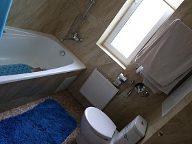 белая ванна с бежевым экраном и бежевой плиткой