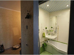 зеркало над белой раковиной и белой ванной через открытую дверь в двухкомнатной квартире новосторя