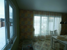 большое окно с белой прозрачной гардиной на яркой цветной стене красивой кухни элитного недостроенного дома