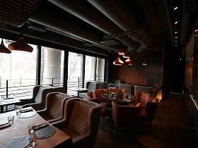 коричневые, бежевые и серые кресла вокруг сервированных столиков в небольшом зале ресторана лофт на Фрунзеской
