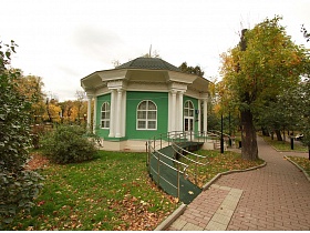 летнее кафе, расположенное в ратонде с зеленым куполом на крыше, белыми колоннами на высоком цоколе со ступенями и пандусом в окружении зелени