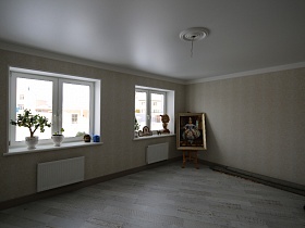 электрический провод без лампочки в белой розетке на белом потолке пустой комнаты с большими окнами,бежевыми стенами и паркетным полом