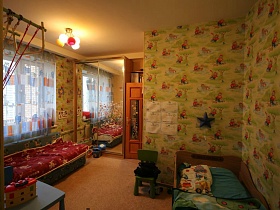 шкаф купе с зеркальными дверцами и разноцветная люстра в детской комнате с мультяшными обоями в современной трешке