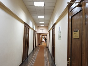 коричневая ковровая дорожка на сером полу длинного светлого коридора с закрытыми дверьми в кабинеты учреждения КГБ СССР для съемок кино