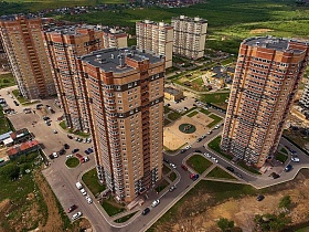 микрорайон с высотными современными жилыми домами с бежево коричневыми стенами, с развитой инфраструктурой на открытом просторе
