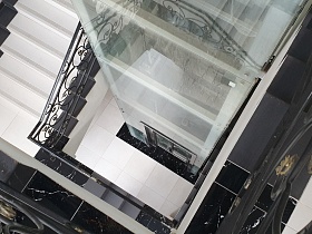вид сверху на лестничную клетку и лофт стекло колодец в стиле хай тек в современном уютном жилом доме