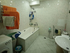 стиральная машинка, корзина для белья,полотенцесушитель, белая ванна,раковина и санузел в светлой ванной комнате трехкомнатной квартиры №16
