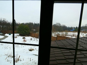 большой участок под снегом за высоким деревянным забором уютного загородного дома для съемок кино